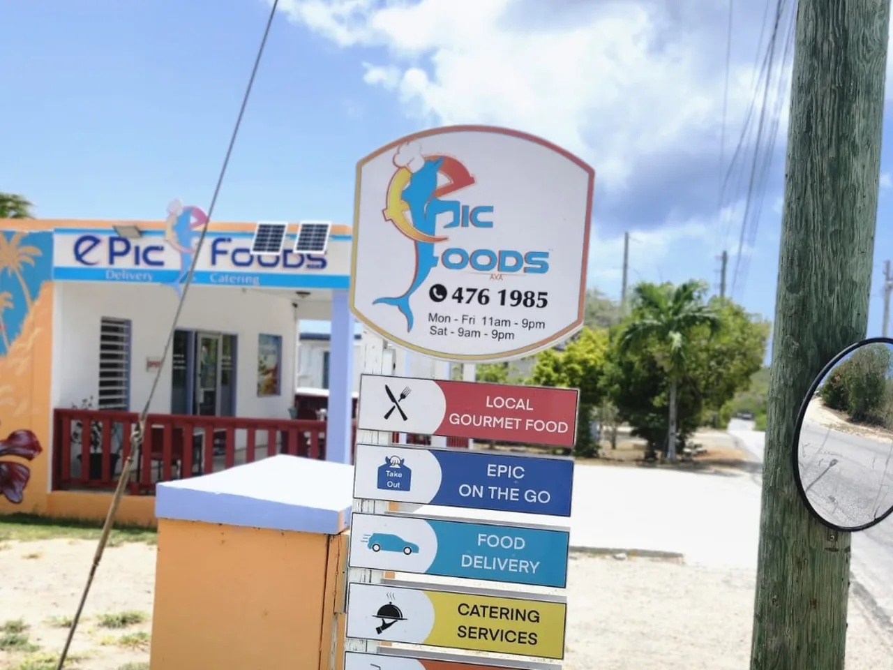 Epic Foods roadside sign showing phone 476 1985 in Long Bay / West End, Anguilla