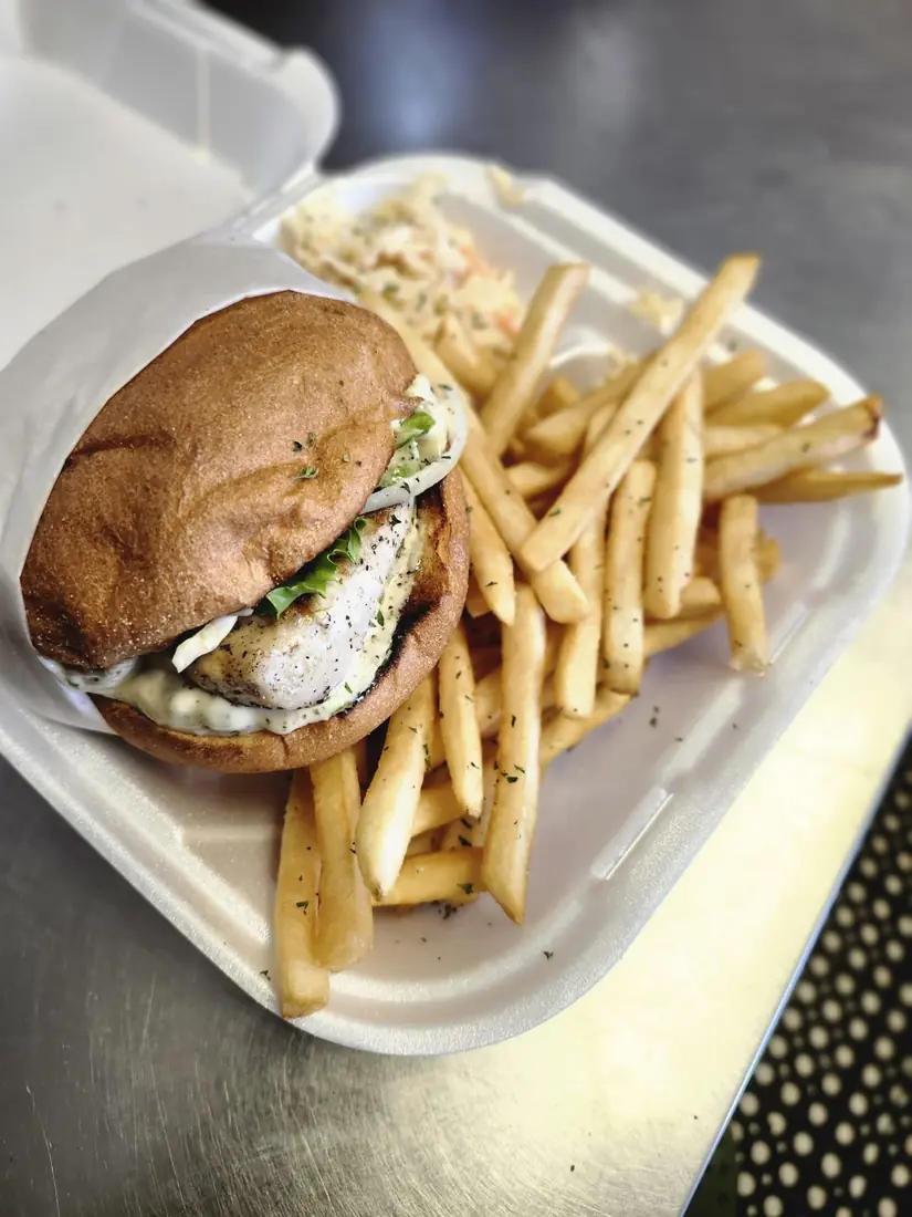 Grilled Mahi Delight sandwich with fries and slaw
